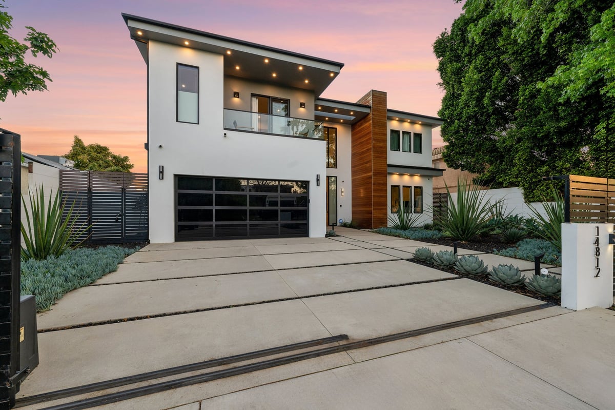 Twilight photo of a modern luxury home with pool, patio, and sleek architectural lines